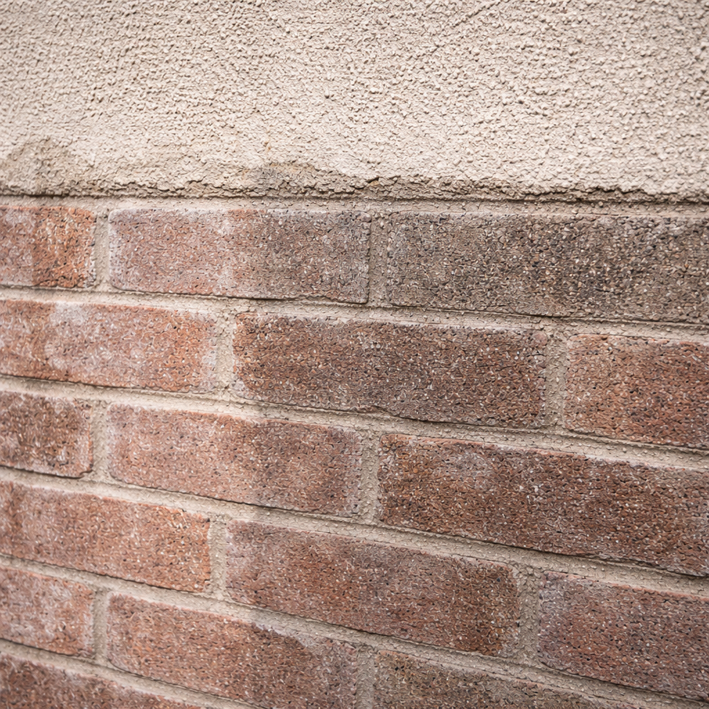 Close-up of a brick wall with a concrete ledge above it