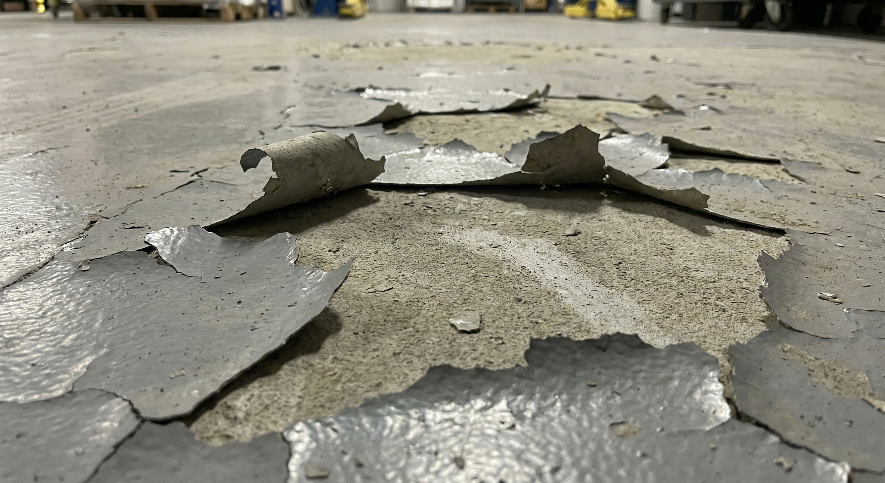 Cracked concrete floor with large pieces of broken material.